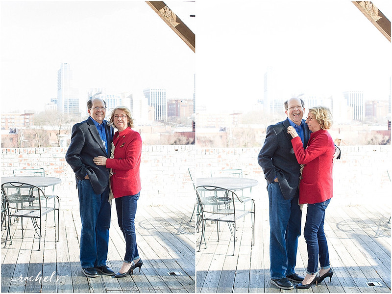 Couple standing by brick wall wearing hats and a red fringe coat with the Raleigh Sky Line