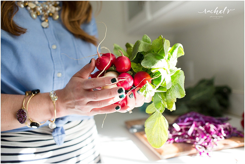Woman in blue shirt holding fresh radishes